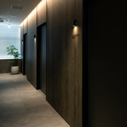 木目調の壁とドアが並ぶ落ち着いた雰囲気のクリニックの廊下